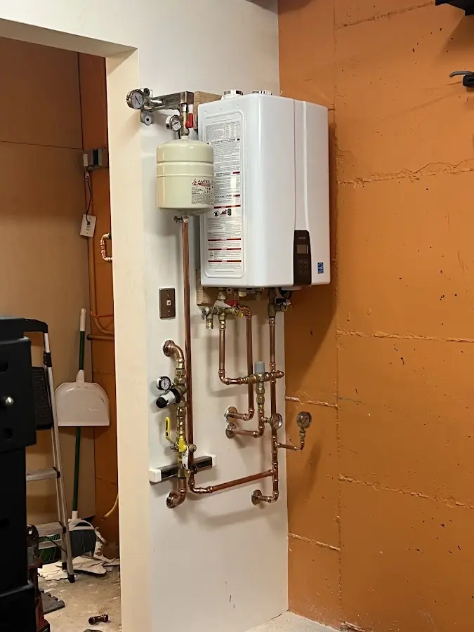 Plumbing technician inspecting water heater connections in Greencastle